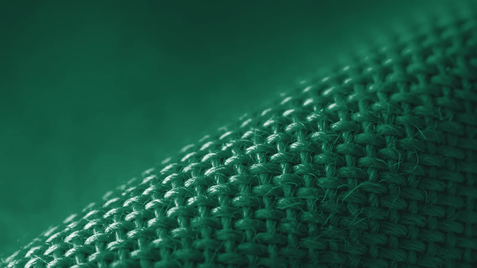 Macro photograph of the weave of raw cotton fabric under grazing light with loose fibres.